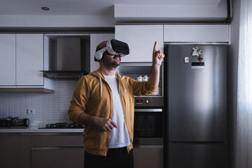 The young man who entered the world of the metaverse from the kitchen. touching with vr glasses.