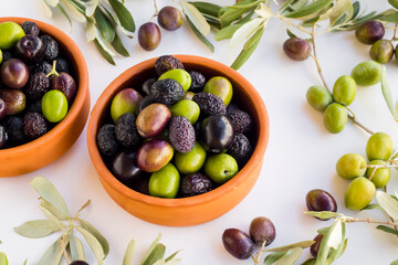 New crop mixed olives in casserole bowl on white background with olive leaves,harvest concept