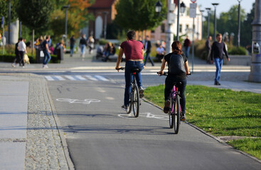 Kobieta i mężczyzna jadą rowerami ścieżką rowerową w mieście, Wrocław. - obrazy, fototapety, plakaty