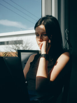 woman working by the window in the sun