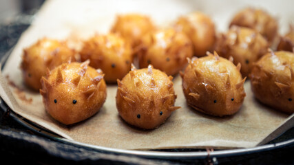 Adorable hedgehog shaped custard pastries dessert. Japanese cake at food market
