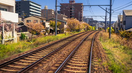 Japanese Kyoto local train traveling on rail tracks along the railway. Japan
