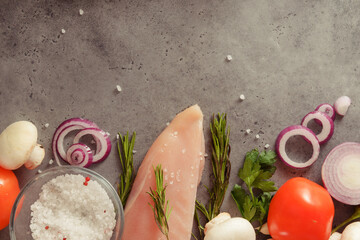 chicken fillet with rosemary, tomato, onion, salt,  mushrooms  top view on a gray background
