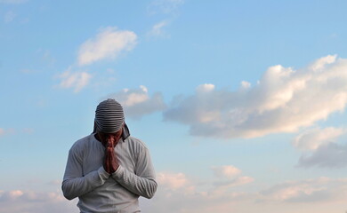 man praying to god with arms outstretched looking up to the sky stock photo	