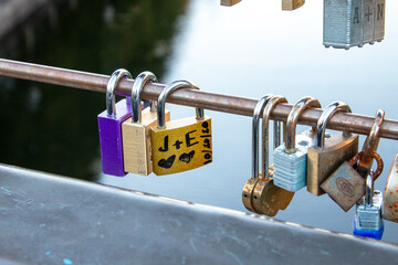 Locks with messages of love hanging from a bridge rail