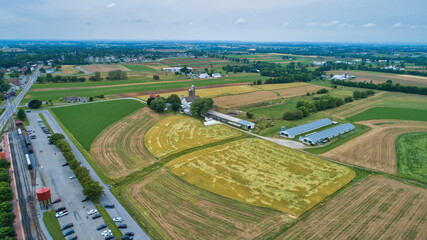 A Beautiful Aerial View of Farm Countryside with Patches of Colored Fields with White Fully Clouds and Shadows