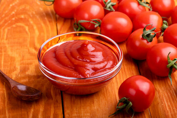 Close-up of ketchup and tomatoes on a wooden background.  Selective focus.