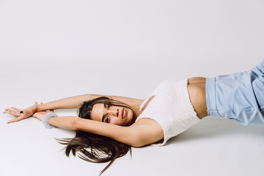 Stylish Hispanic model in crop top on light background