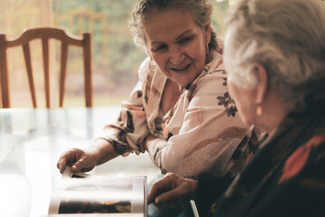 Aged women examining photos together
