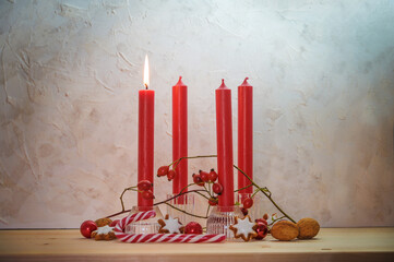 Four red candles, one is lit for the first Sunday before Christmas, Advent decoration on a wooden...
