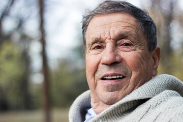 Portrait of happy senior man in the park. Elder health and retirement concept