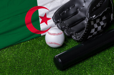 Baseball bat, glove and ball near Algeria flag on green grass background