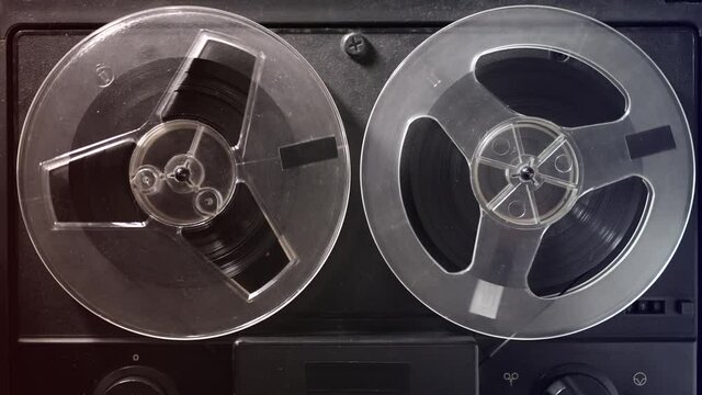 Vintage tape recorder roller. Reel film tape is rotating at a oldschool professional player. Concept of spying and recording a phone conversations