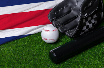 Baseball bat, glove and ball near Costa Rica flag on green grass background