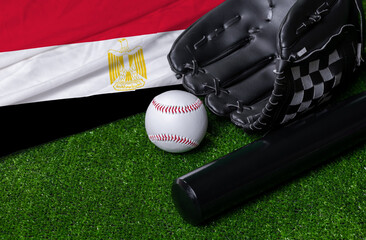 Baseball bat, glove and ball near Egypt flag on green grass background