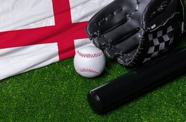 Baseball bat, glove and ball near England flag on green grass background