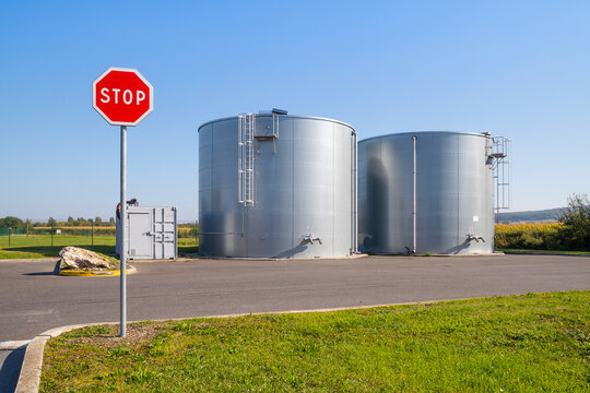 Signe STOP sur fond de cuves &agrave; essence