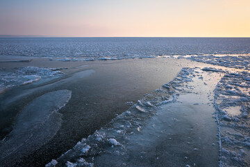 Sunrise and frozen sea. Beautiful winter landscape with lake in morning time.