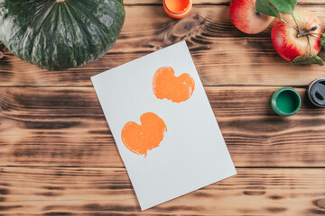 Naklejka na ściany i meble Step-by-step Halloween tutorial pumpkin apple prints. Step 9: Prints on paper of half apple painted in orange gouache