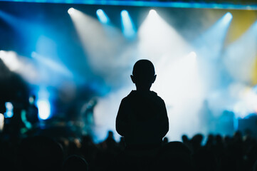 Child in a audience crowd having fun and enjoying concert on a festival