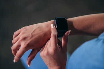 Woman in sportswear checks fitness and health tracking on her smartwatch after training