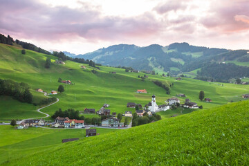 Fototapeta na wymiar Little rural village and a church in Switzerland hills