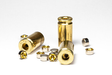 Reloading/handloading - closeup of decapped and cleaned 9mm Brass/casing primer pockets and small pistol primers. - obrazy, fototapety, plakaty