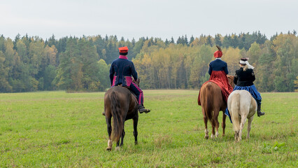 Group of fox hunters on the horses in the autumn field. Reconsruction of traditional horse hunting.
