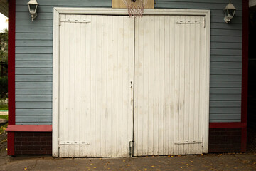White garage door. Entrance to the house. Wooden gate to the utility room.
