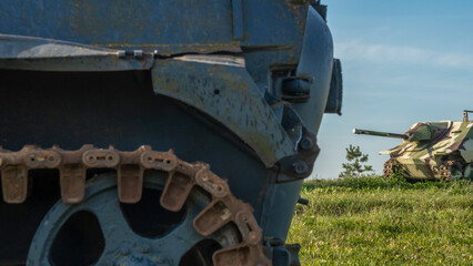 Vintage German World War 2 armored combat tank poised on the battlefield. In the foreground is a tank caterpillar.