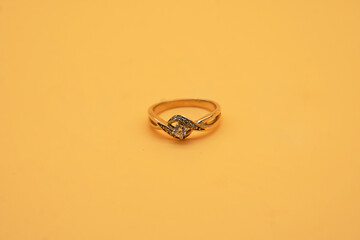 gold ring surrounded by diamonds on the yellow background