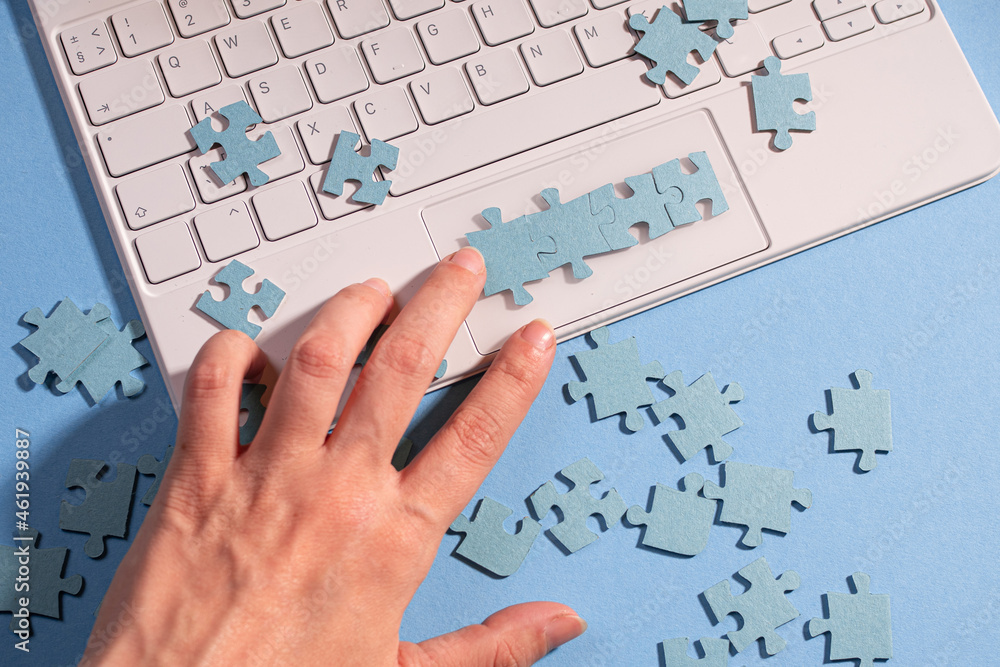 Poster puzzle elements on a laptop keyboard, software development, concept. mosaic on a blue background