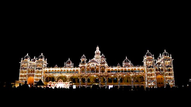 A Dramatic night view of the famous landmark Maharajah's Ambavilas Palace decked up with Electric lights for the Dasara festival 2021 in Mysuru, India.