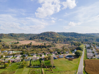 rural neighborhood and farm land in autumn in midwest; mountains with trees and open landscape; farm fields after harvest; family friendly single-family homes and mobile home park for diversity.   