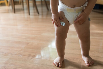 Toddler touches bandage after being given a vaccine; 15 month old baby