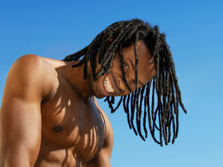 Handsome man smiling under the sun at the beach, blue sky, photo, horizontal format