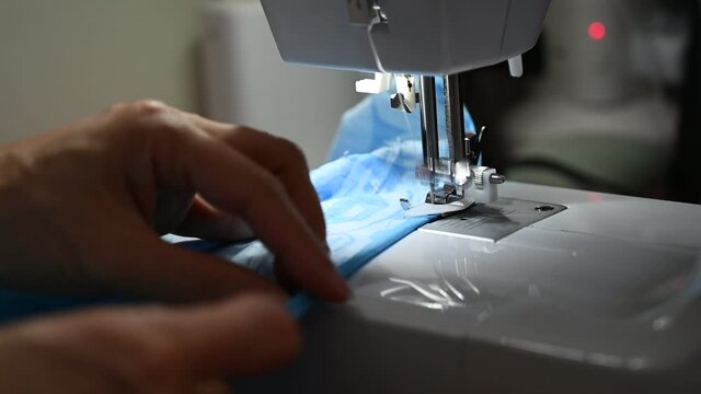A tailor is altering clothes with sewing machine.