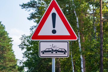 Ein Straßenschild mit dem Symbol das Achtung vor zusammen fahrenden Autos anzeigt