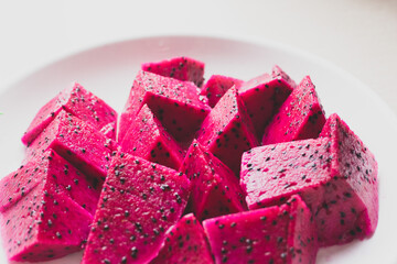 Ripe dragon fruit isolated on white background. Sweet pitaya on a plate,  space for text