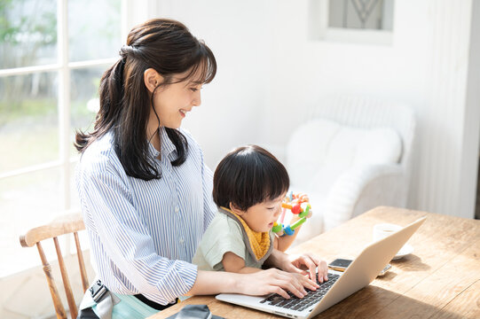 リモートで在宅ワークをする働くママ  横から 
仕事ができない笑1　アップ コピースペースあり