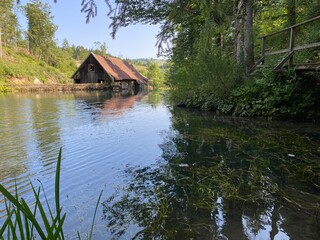 Obraz premium Remains of an old sawmill on the small dam of Čogrljevo Lake in the mountain hamlet of Tići - Gorski kotar, Croatia (Ostaci stare pilane na maloj brani Čogrljevog jezera u goranskom zaselku Tići)