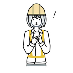 立ってスマートフォンを操作して何かに気づいて驚いた工事現場の女性