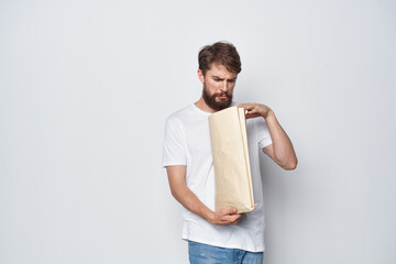 bearded man in a white t-shirt with a package in his hands emotions mockup