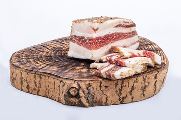 wooden board in retro style. a piece of bacon is cut into pieces on it. on a white background. close-up.