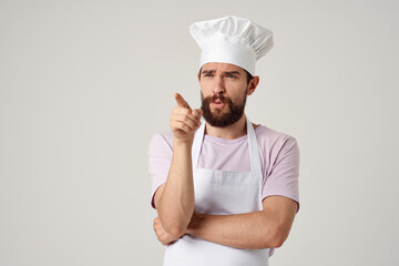 Cheerful male chef in uniform cooking food kitchen light background