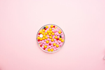 Fototapeta na wymiar multicolored pills medicine pain reliever pink background