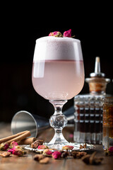 Female pink cocktail with foam in a glass. decorated with dried rose.