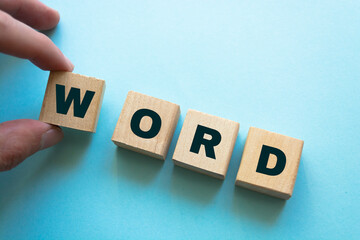 Man puts a wooden blocks with the inscription Word. The structural unit of language. Morphology....