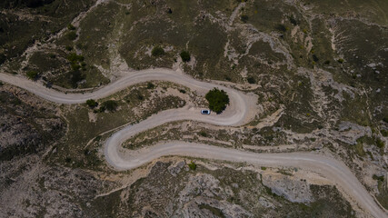 Vehicle Moving along Serpantine Road in Highlands. Aerial View