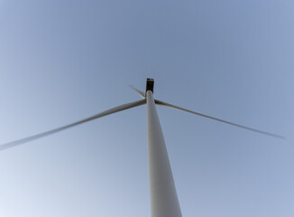 View from below to a windmill to generate renewable electricity, with the light of dawn.